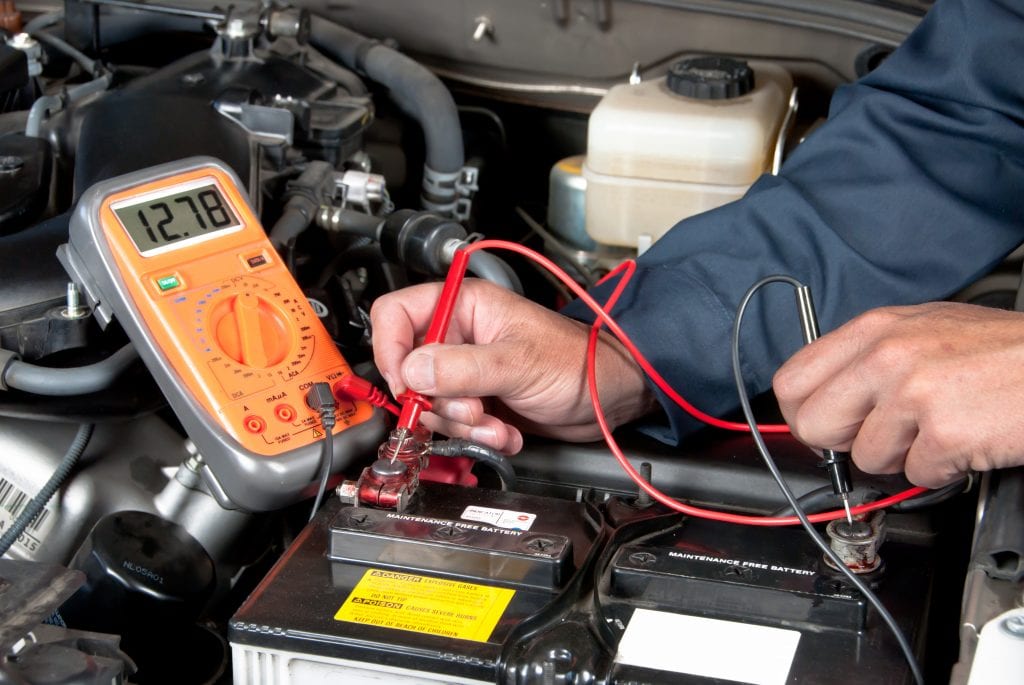 Safe RV Travel auto mechanic checking car battery voltage